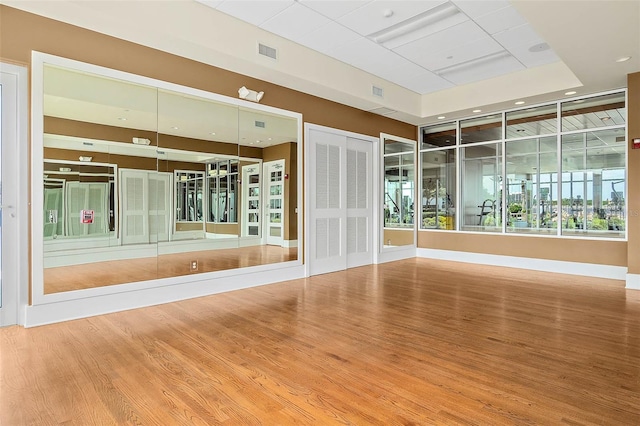 empty room featuring wood-type flooring and a tray ceiling