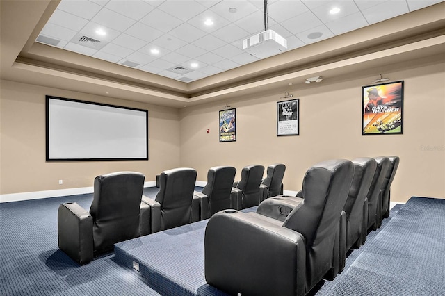 carpeted cinema featuring a tray ceiling and a drop ceiling