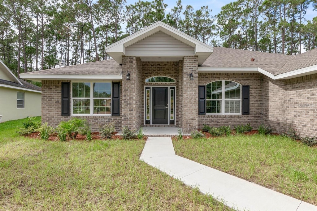 ranch-style house with brick siding and a front lawn