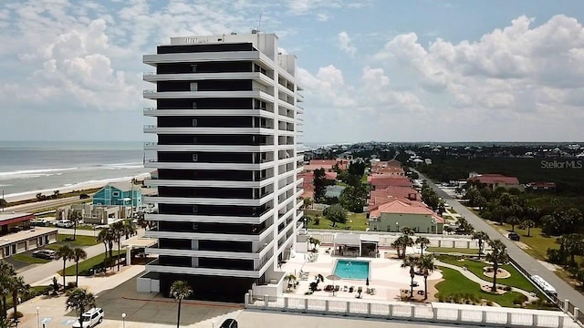 view of building exterior with a water view and a community pool