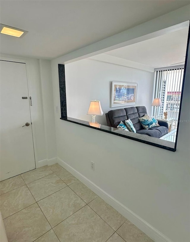 empty room featuring light tile patterned flooring and baseboards