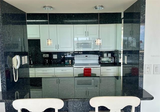 kitchen featuring a toaster, white appliances, dark countertops, and white cabinets