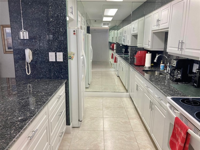 kitchen with white appliances, a sink, white cabinetry, backsplash, and decorative light fixtures