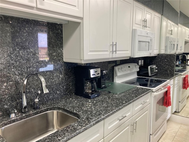 kitchen with white appliances, white cabinetry, decorative backsplash, and a sink