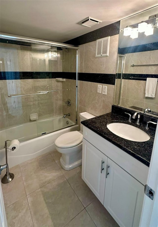 bathroom with tile patterned flooring, visible vents, combined bath / shower with glass door, and tile walls