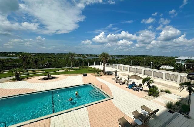 community pool featuring a patio and fence