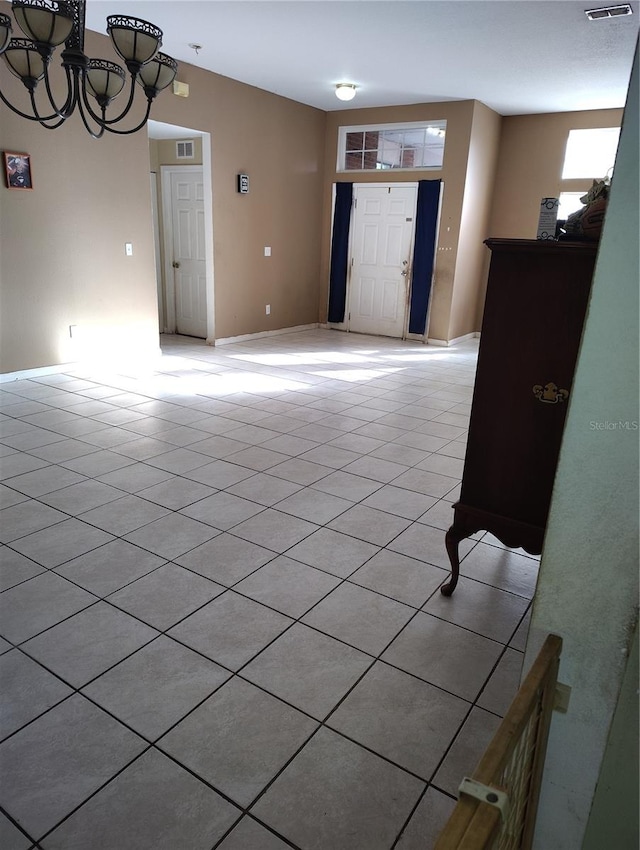 tiled entryway with an inviting chandelier