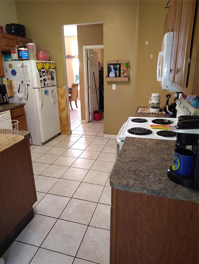 kitchen featuring light tile patterned floors and white appliances