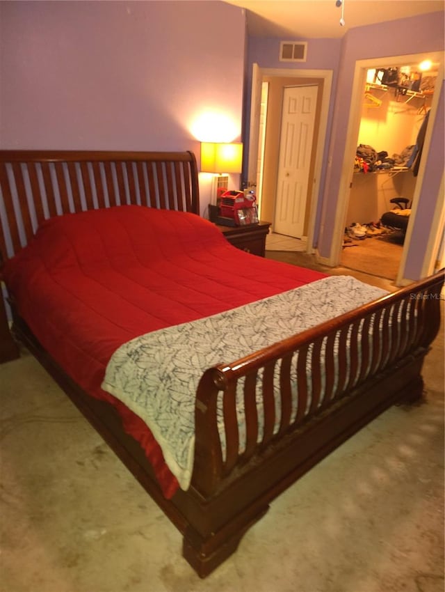 carpeted bedroom with a walk in closet and a closet