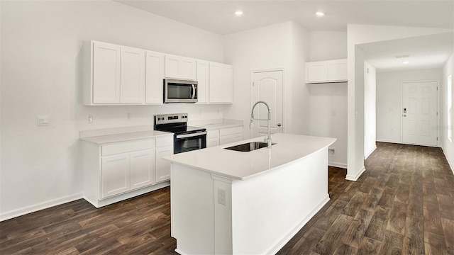 kitchen featuring a sink, white cabinetry, light countertops, appliances with stainless steel finishes, and a center island with sink