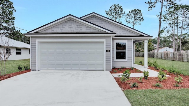 view of front of home with a garage, driveway, a front yard, and fence