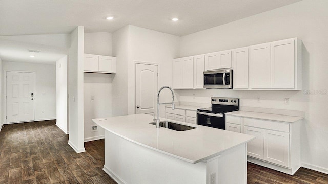 kitchen with light countertops, stainless steel microwave, a center island with sink, and electric range