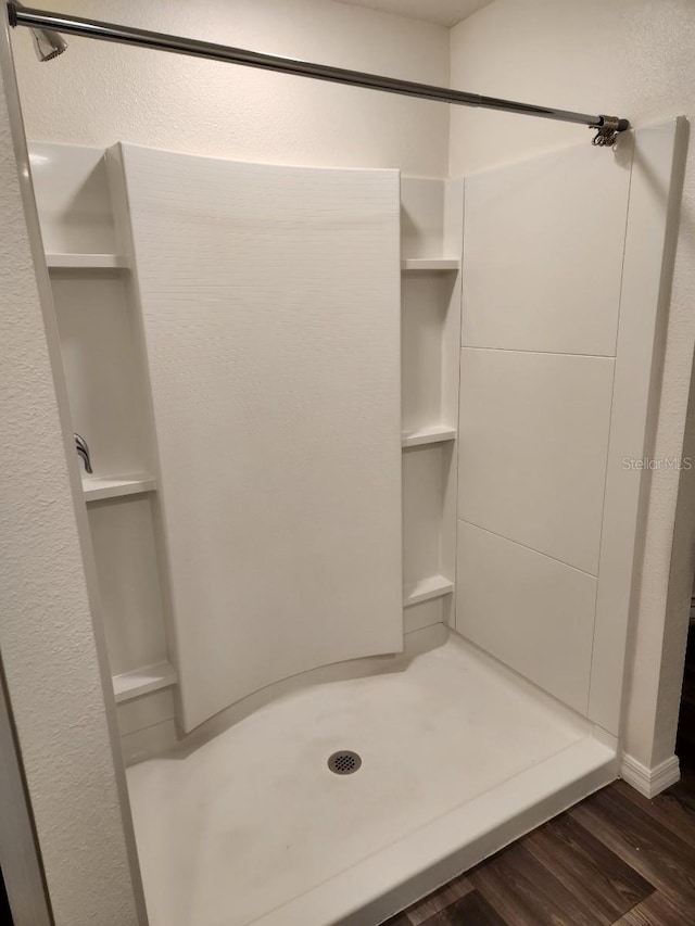 bathroom with hardwood / wood-style floors and walk in shower