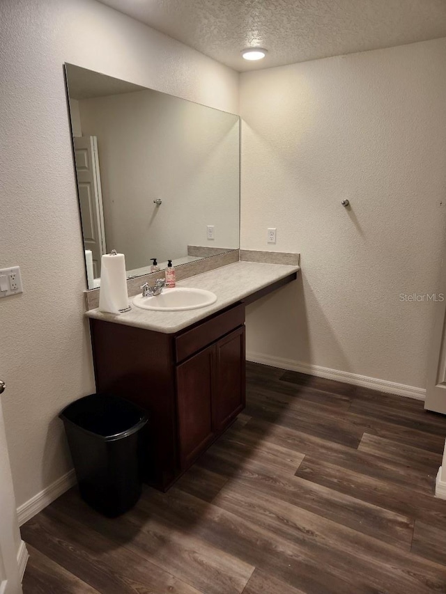 bathroom with vanity, a textured ceiling, and hardwood / wood-style flooring