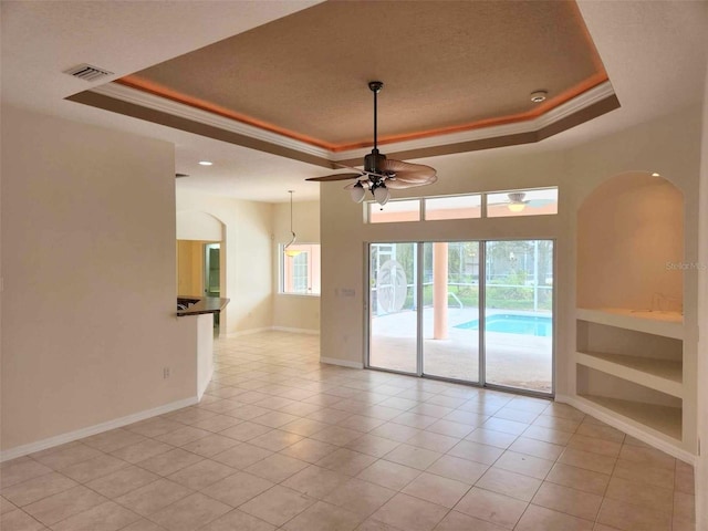 23 Flemington Ln, Palm Coast, FL 32137 - spare room with a tray ceiling, a ceiling fan, ornamental molding, baseboards, and arched walkways