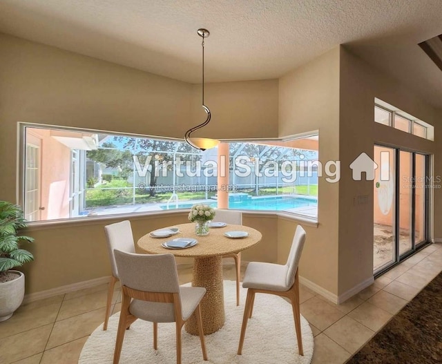 dining area featuring light tile patterned floors, a healthy amount of sunlight, and a textured ceiling