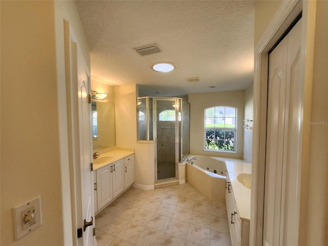 bathroom with shower with separate bathtub, vanity, and a textured ceiling