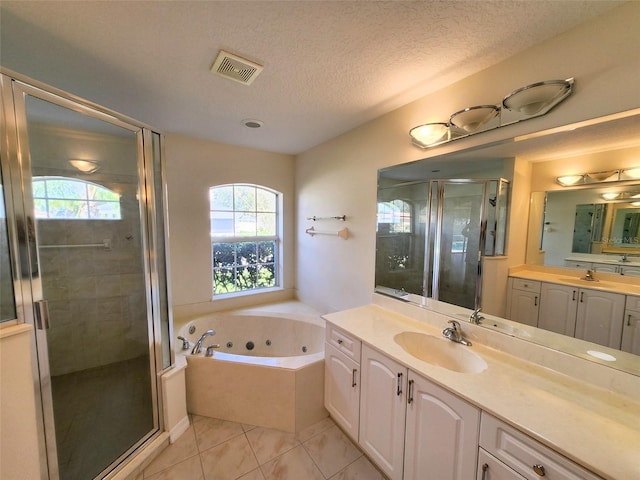 bathroom with tile patterned floors, vanity, a textured ceiling, and independent shower and bath