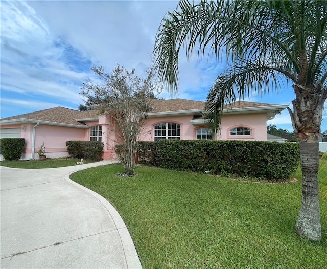 ranch-style home with a front yard and a garage