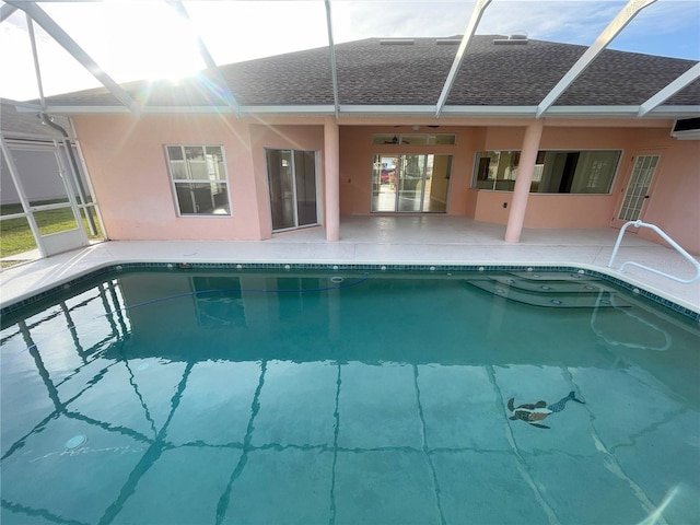 view of swimming pool with glass enclosure, ceiling fan, and a patio area