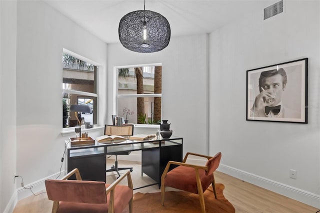 office space with visible vents, baseboards, and wood finished floors