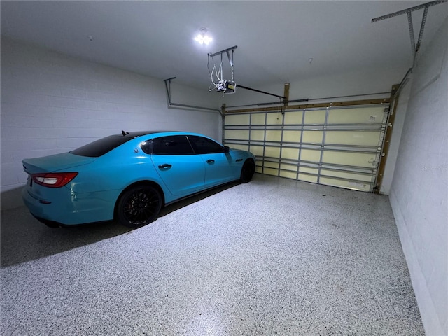 garage with concrete block wall and a garage door opener