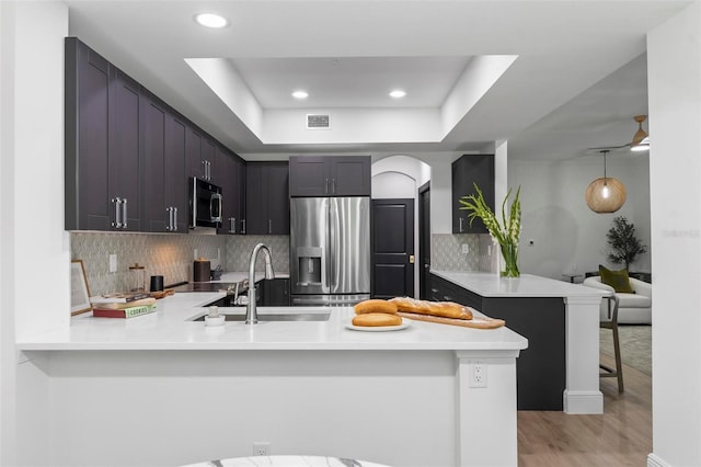 kitchen featuring a sink, a peninsula, visible vents, and stainless steel appliances