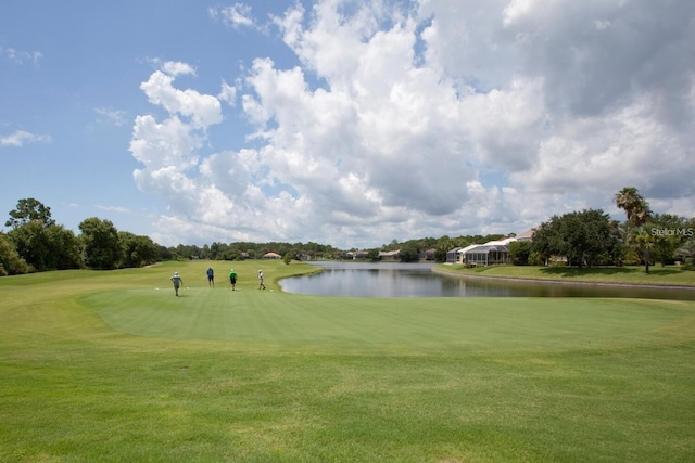 view of property's community featuring a yard, a water view, and view of golf course