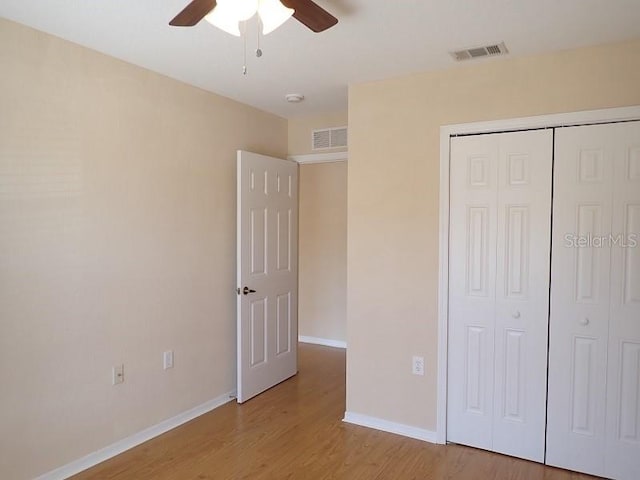 unfurnished bedroom with ceiling fan, light hardwood / wood-style flooring, and a closet