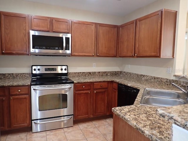 kitchen with sink, appliances with stainless steel finishes, light stone countertops, and light tile patterned floors