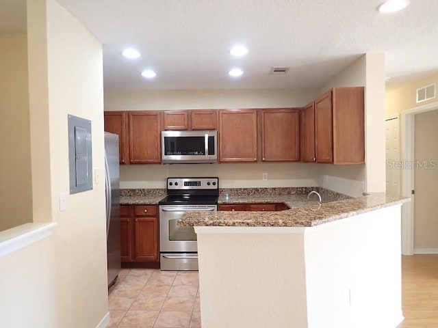 kitchen featuring stainless steel appliances, light hardwood / wood-style floors, electric panel, light stone countertops, and kitchen peninsula