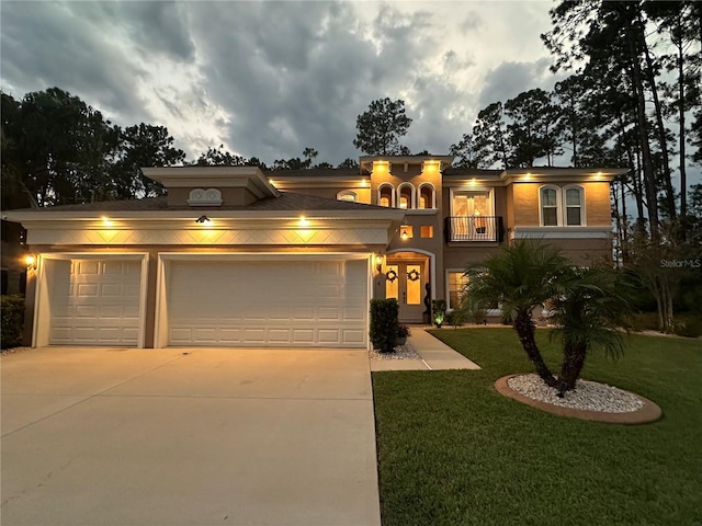 mediterranean / spanish house featuring a garage, driveway, a front yard, and a balcony