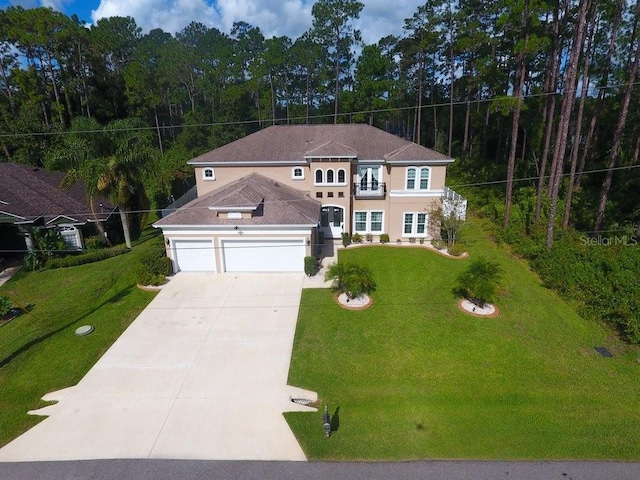 view of front of home with concrete driveway, a front yard, a balcony, and stucco siding