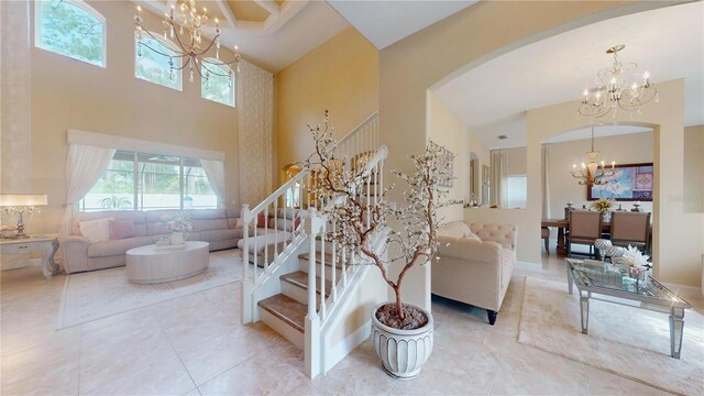 living room featuring a notable chandelier, a high ceiling, and light tile patterned floors