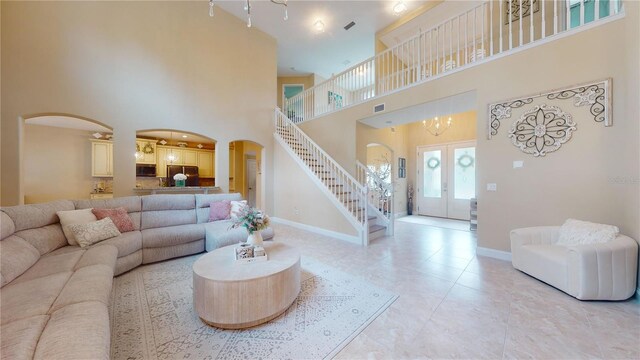 tiled living room featuring a towering ceiling