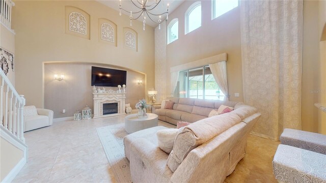 tiled living room with a towering ceiling, an inviting chandelier, and a premium fireplace