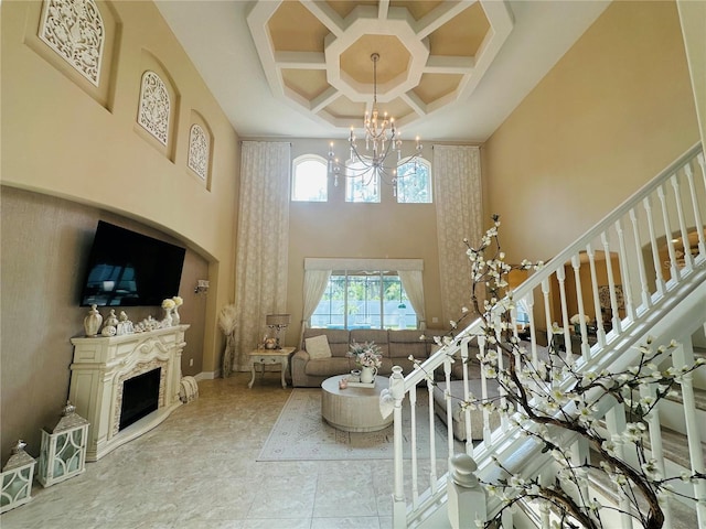 living area featuring stairway, a fireplace, a high ceiling, and a wealth of natural light