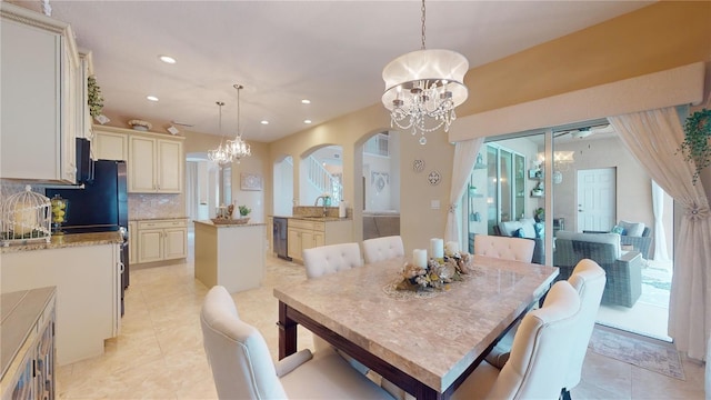 dining room featuring light tile patterned floors, arched walkways, a notable chandelier, and recessed lighting