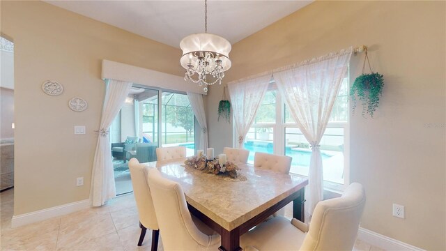 dining space with light tile patterned floors and an inviting chandelier