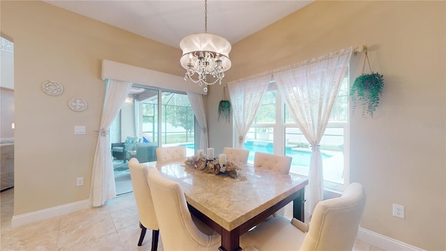 dining area featuring a chandelier, light tile patterned flooring, and baseboards