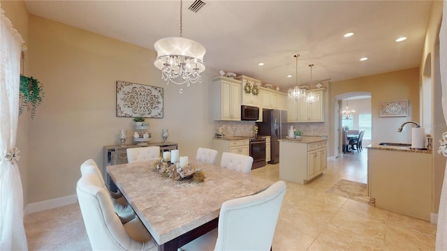 dining space with a chandelier, arched walkways, visible vents, and recessed lighting