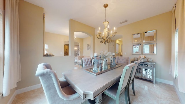 dining room with visible vents, arched walkways, a chandelier, and baseboards