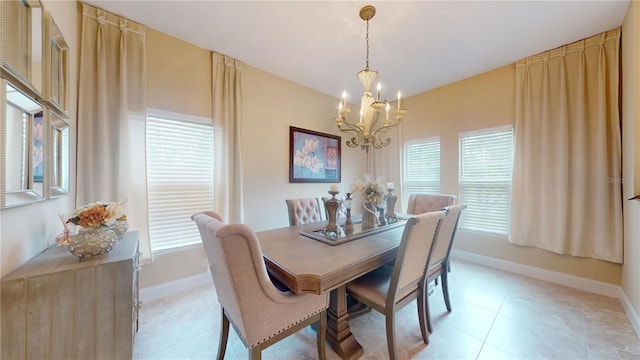 dining room featuring light tile patterned flooring, baseboards, and an inviting chandelier