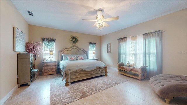 tiled bedroom featuring ceiling fan and multiple windows