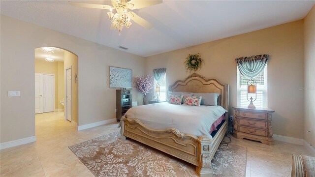 bedroom featuring ceiling fan, light tile patterned flooring, and multiple windows