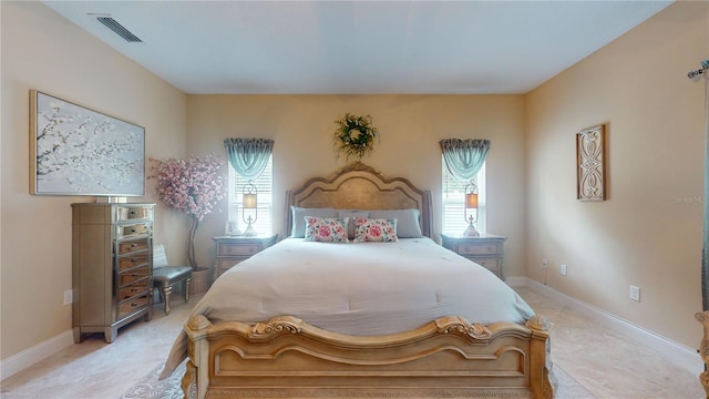 bedroom featuring multiple windows, visible vents, and baseboards