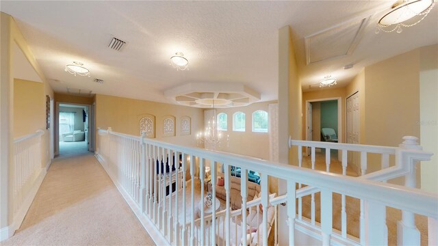 hall with carpet floors and a notable chandelier