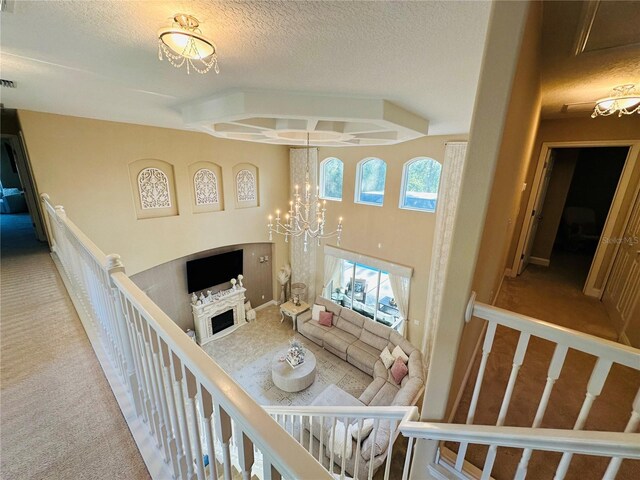 carpeted living room featuring a textured ceiling and a chandelier