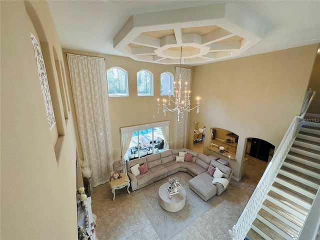 living room featuring coffered ceiling, stairway, a high ceiling, and an inviting chandelier