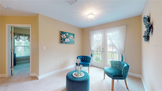 living area with carpet, visible vents, baseboards, and french doors